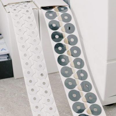 White cardboard boxes with adhesive tape with anti slip pads for hydrophobic optical lenses placed on marble surface in workspace